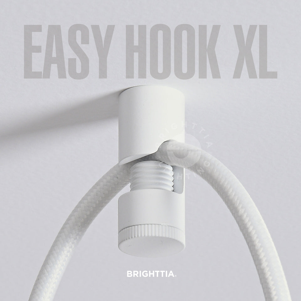 A white easy hook XL mounted on white ceiling with a white fabric cord hanging on it.