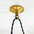 Brass ceiling hook with black cord on a white background