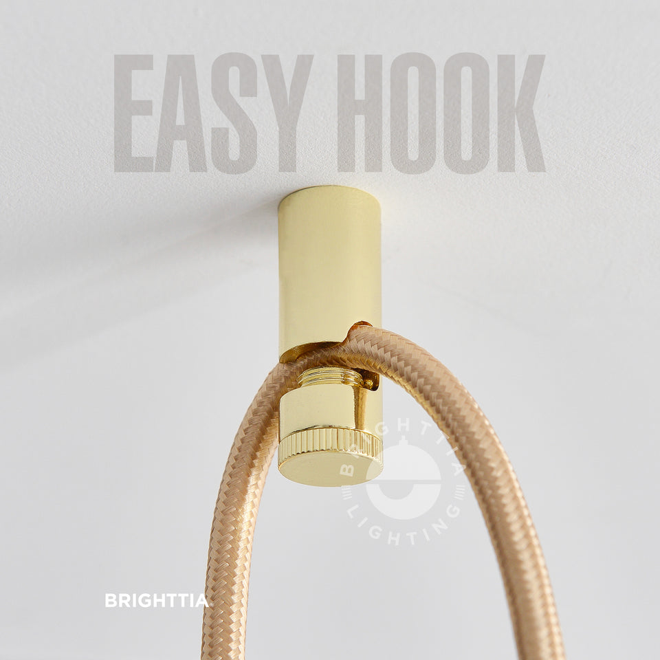 Brighttia Easy Hook in gold mounted on white ceiling with a gold fabric cord hanging on it.