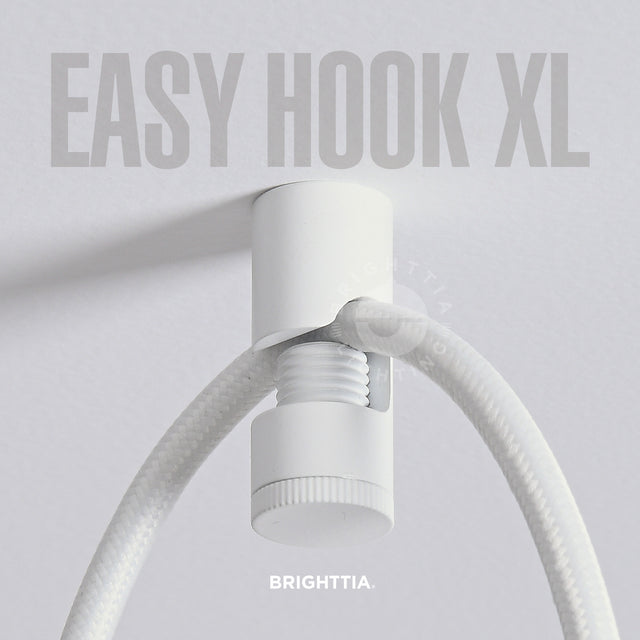 A white easy hook XL mounted on white ceiling with a white fabric cord hanging on it.